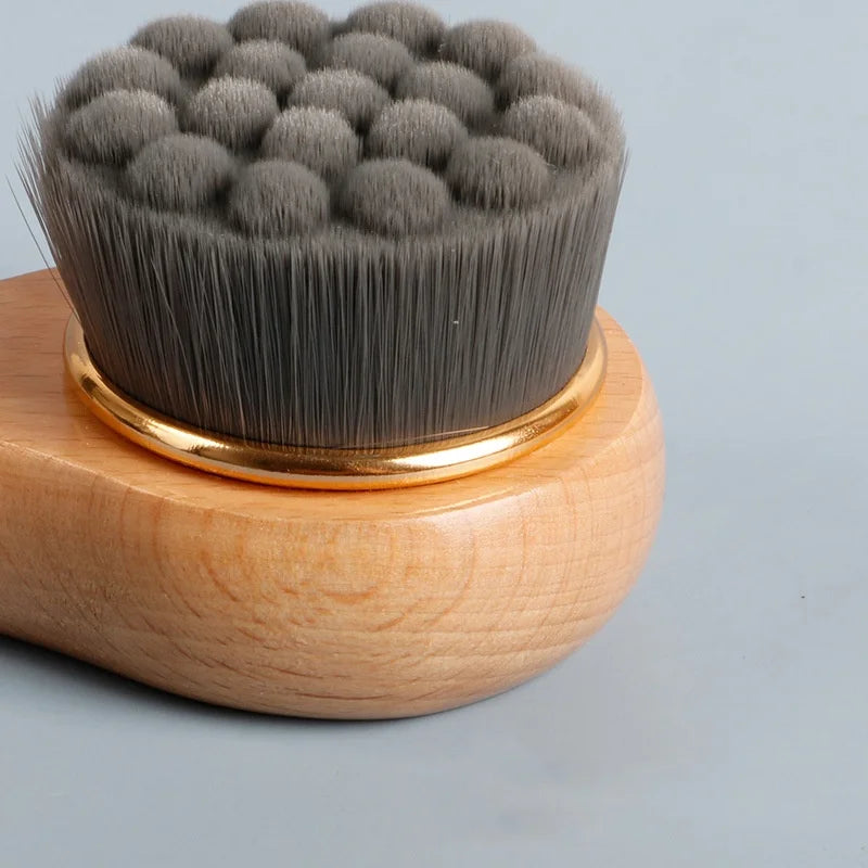 Cosmetic brush with wooden handle and gray bristles on a light gray background